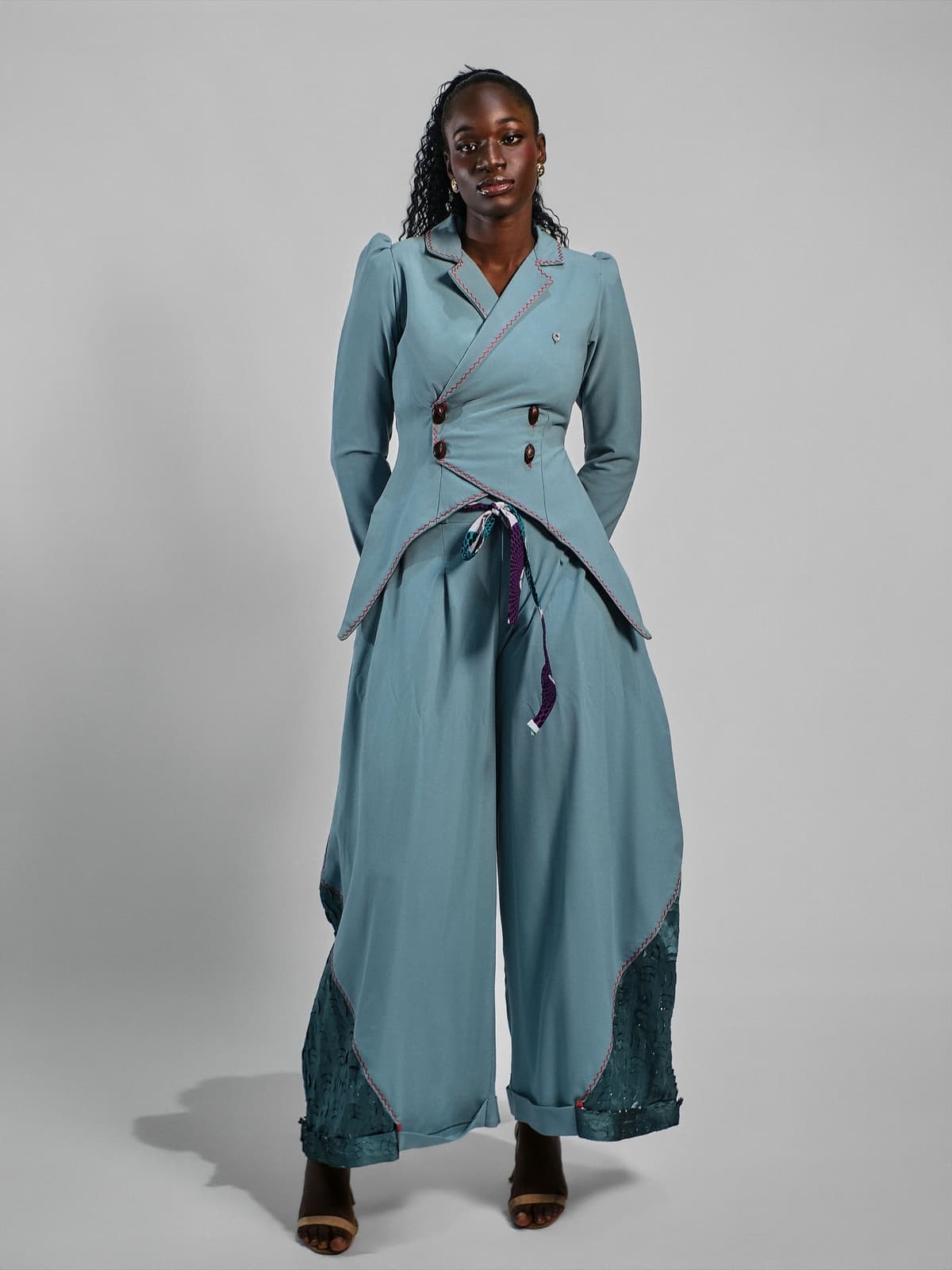 Teal double-breasted jacket and wide trousers with patterned turn-ups.